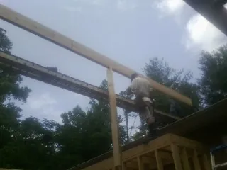 Carpenter setting a ridge beam over a new addition frame — Ice Dam Removal by Roofing Brothers in Mountain Home